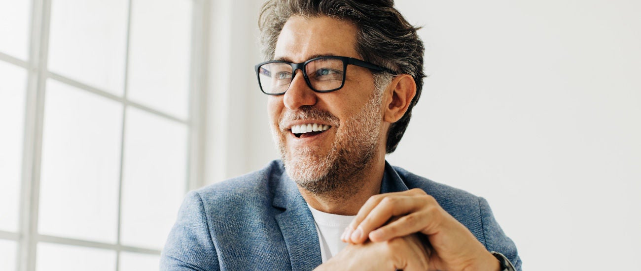A man in glasses smiling.