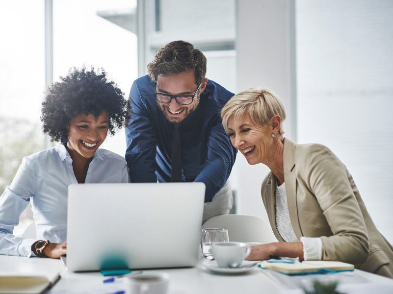 Three people looking at a laptop