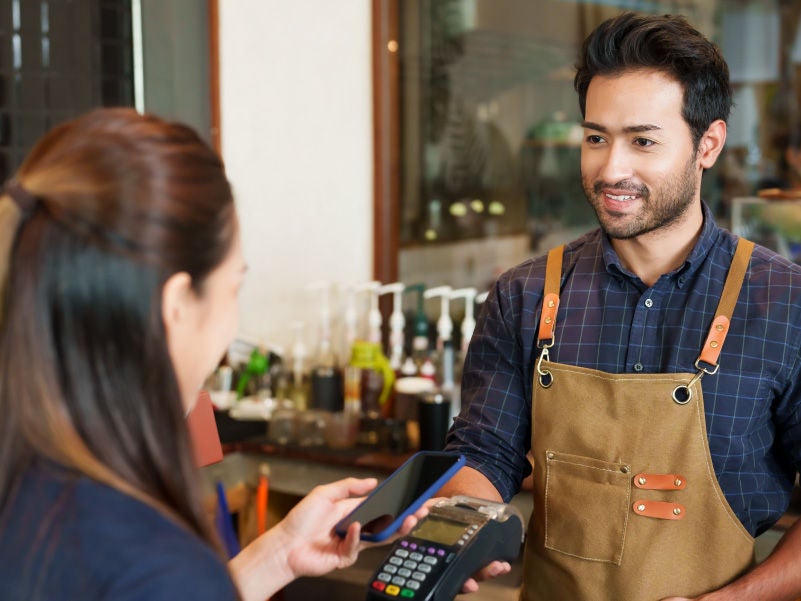 A business owner holding a card reader.