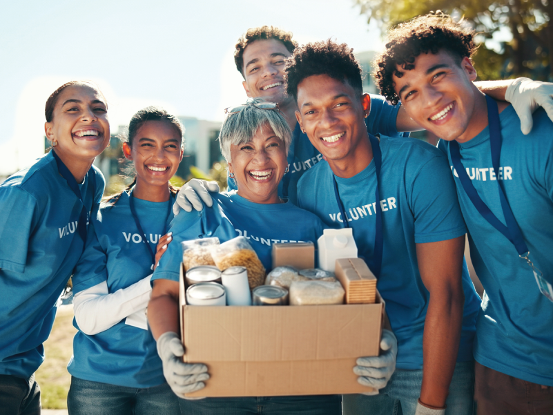 A group of volunteers holding a full donations box. 