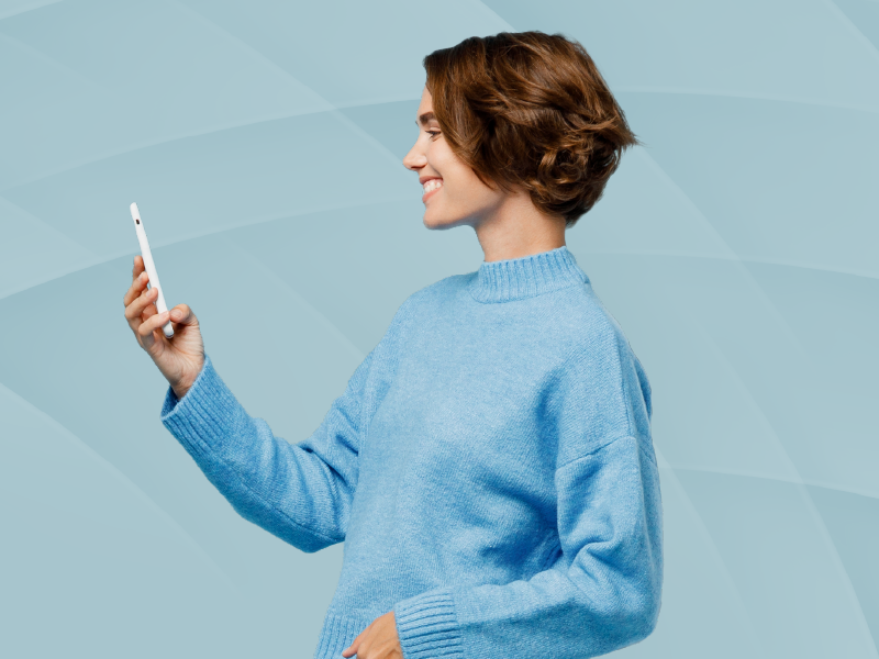 A woman holding a smartphone and smiling.