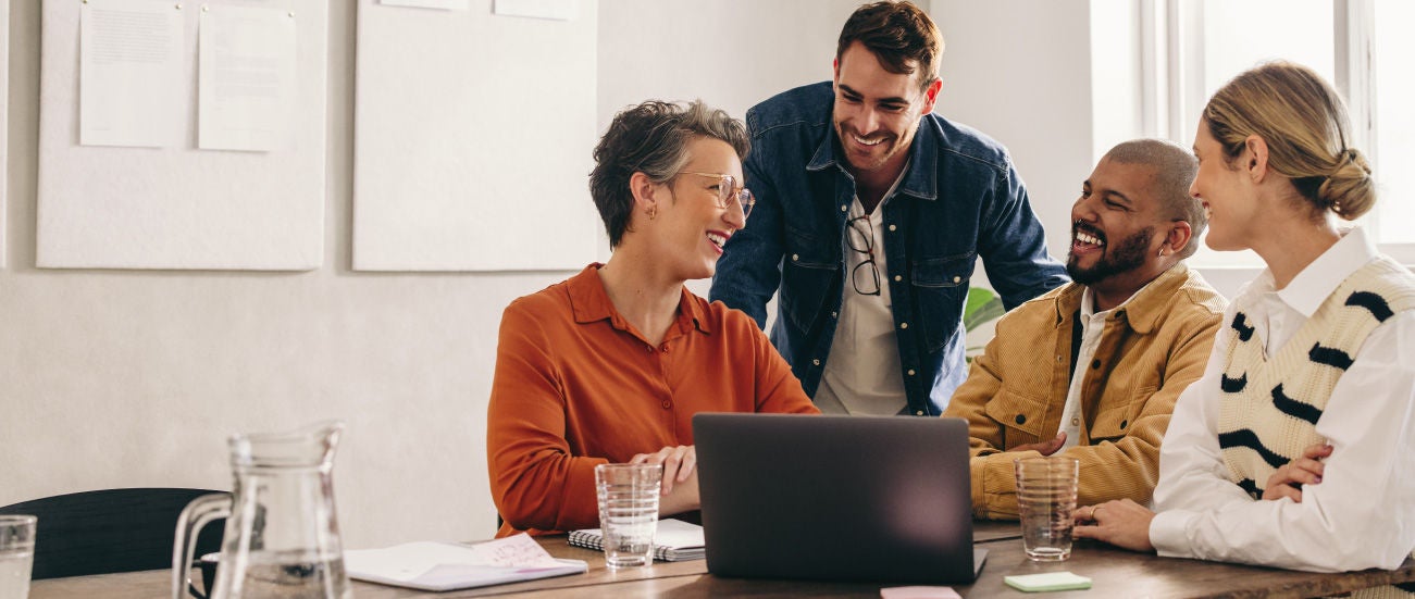 A group of business people around a computer.