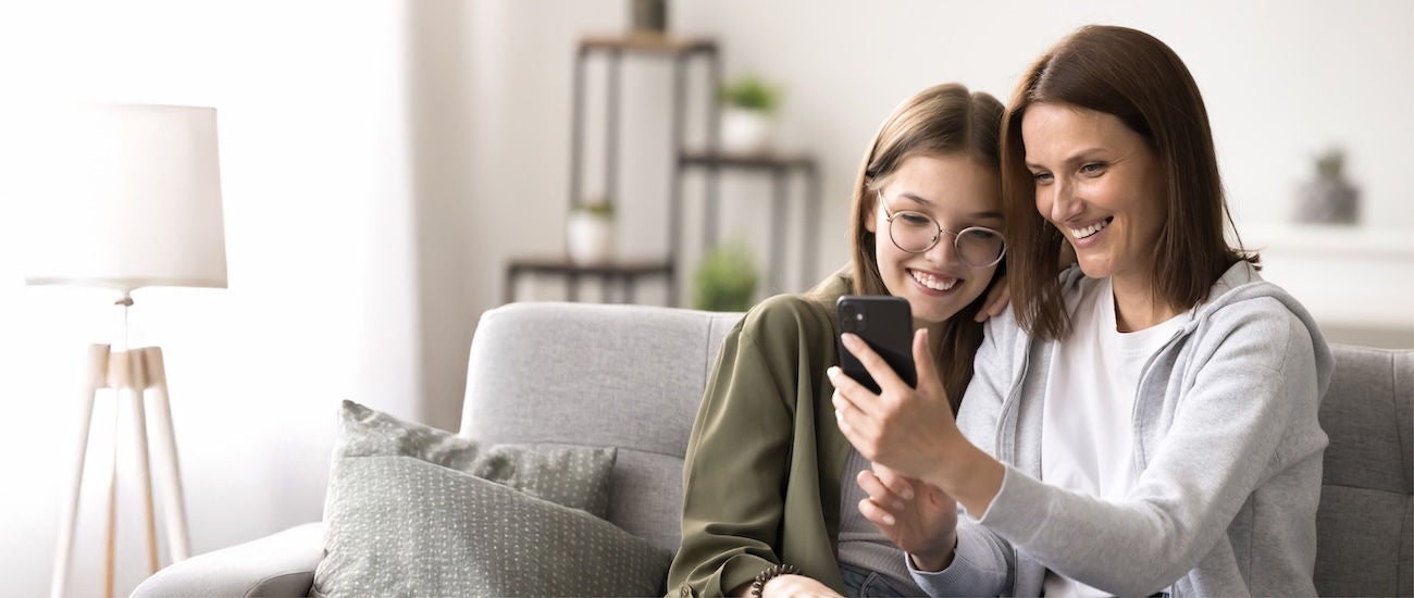 a mother and daughter looking at their phones
