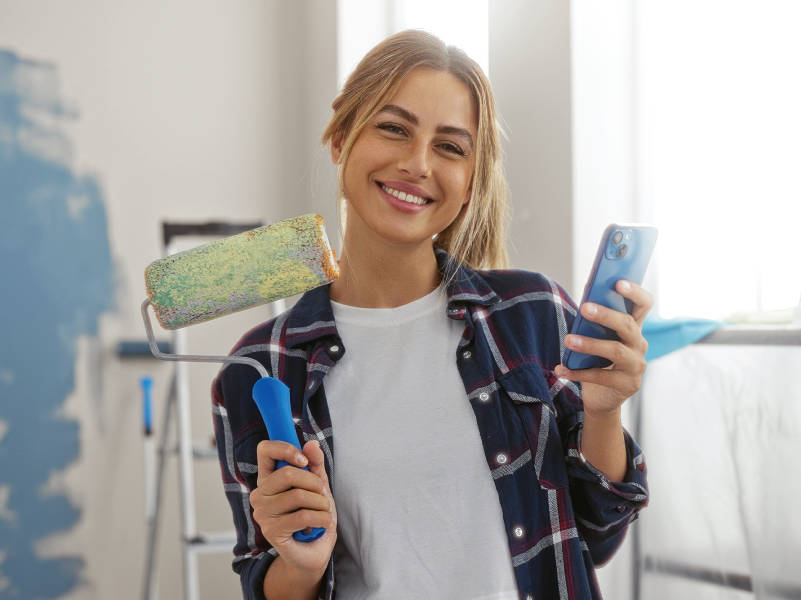 A woman holding a paint roller.