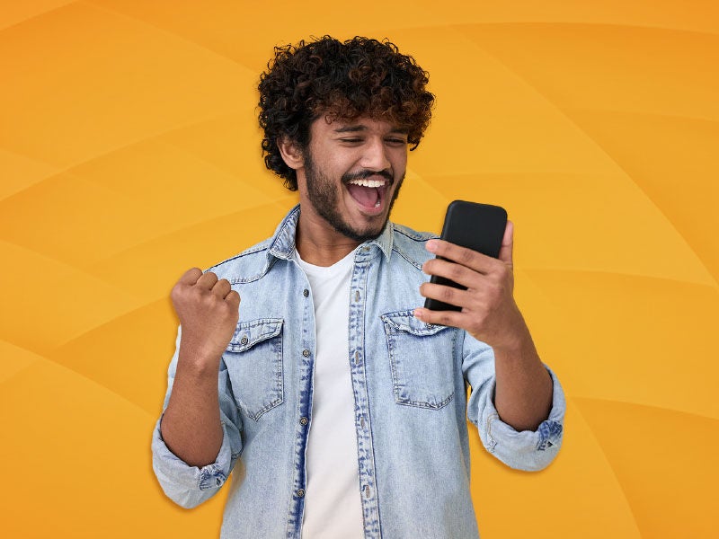 An image of a man holding his cell phone and getting excited. 