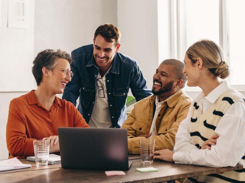 A group of business people around a computer.