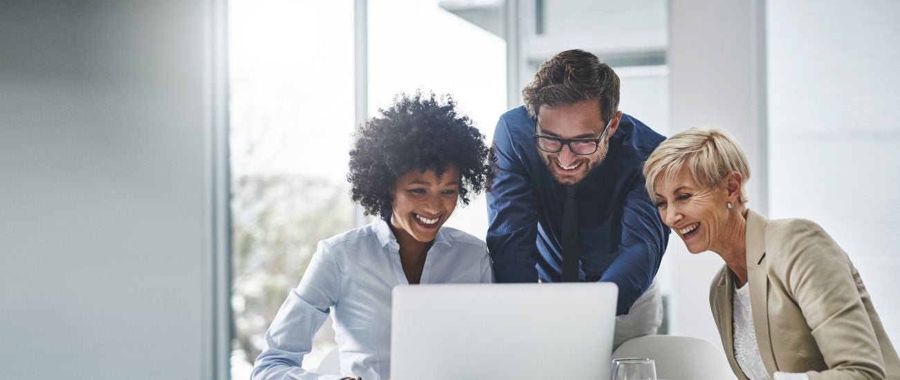 Three people looking at a laptop