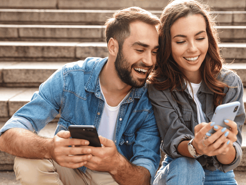 a man and woman on smartphones.