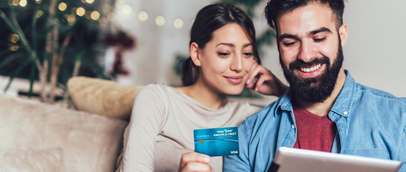 A man and woman looking at a smartphone and smiling.