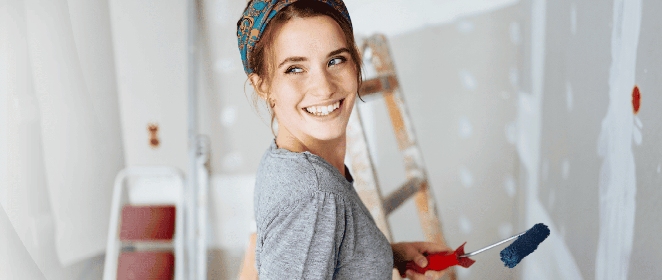 A woman holding a paint roller.