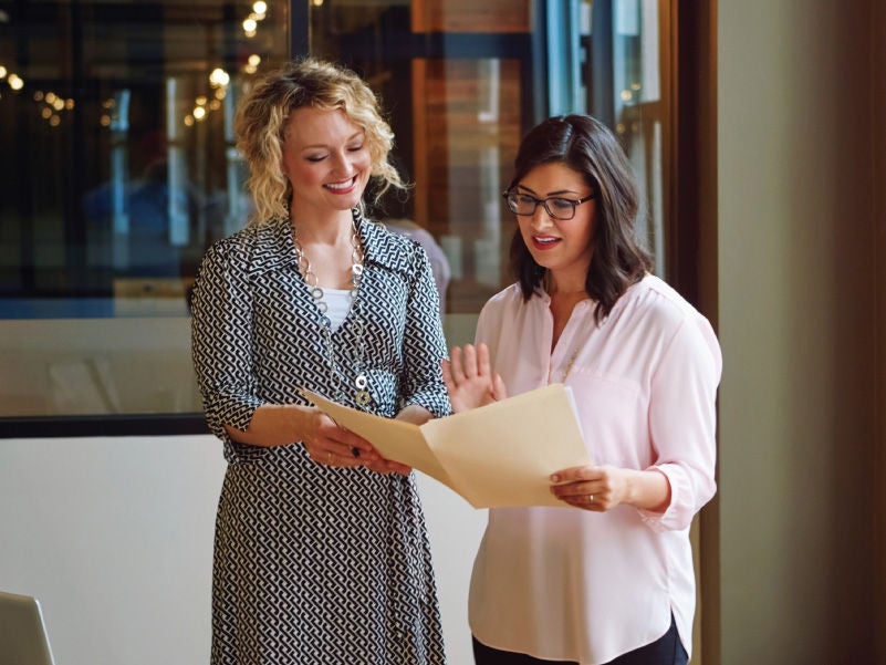 Two women looking at a file folder