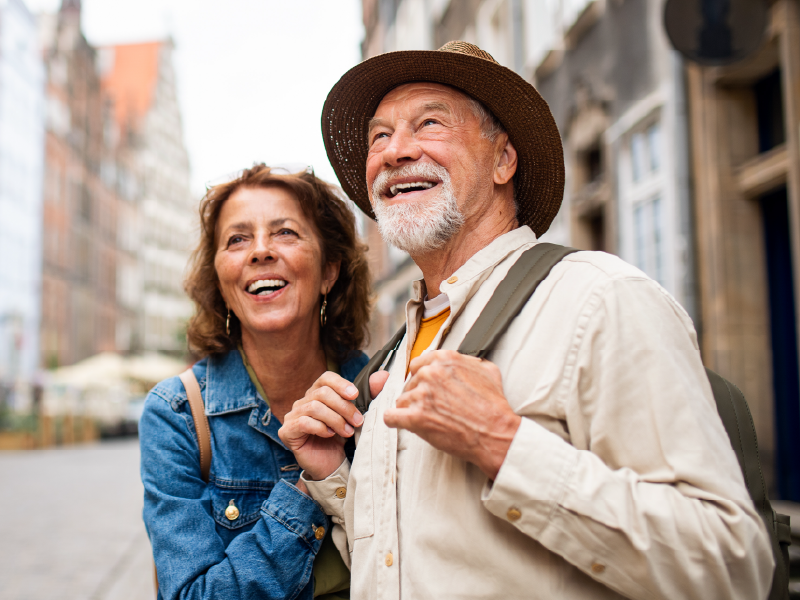 A retired couple walking through a foreign city. 