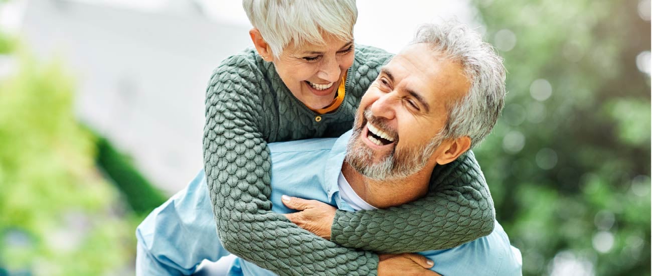 a retired couple with their arms around each other