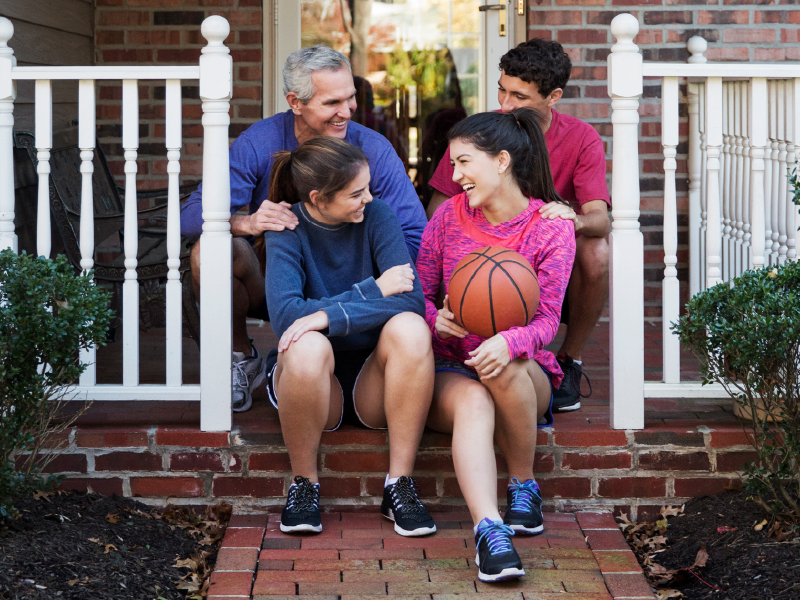 A famly sitting on a pourch