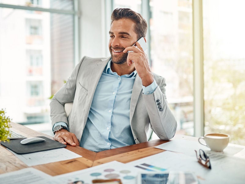 A business professional on a tablet and cell phone.