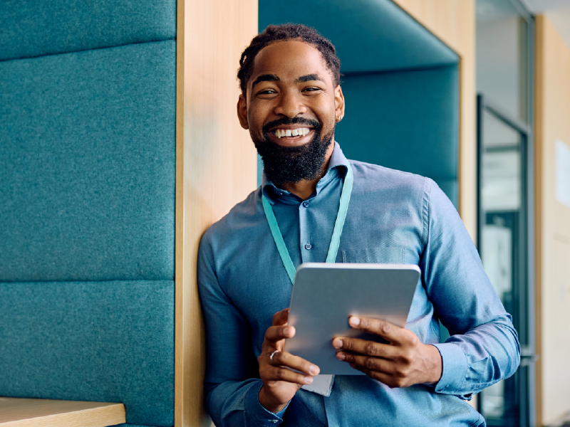  business professional holding a tablet and smiling.