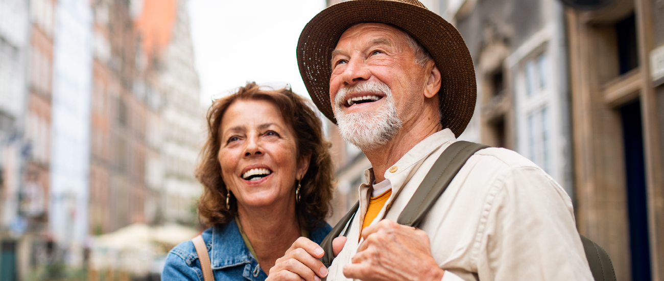 A retired couple walking through a foreign city. 