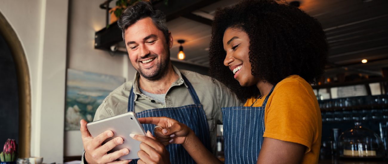 an image of a man and woman planning business strategies on a tablet.