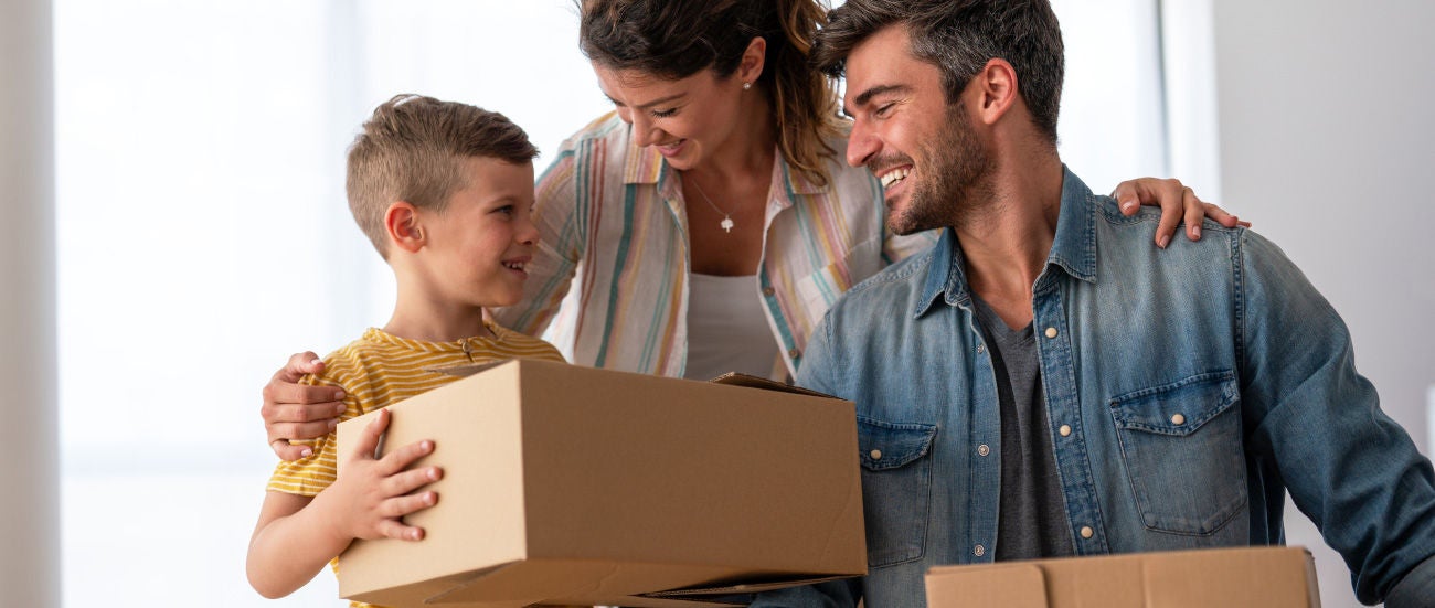 Man, woman and child holding boxes. 