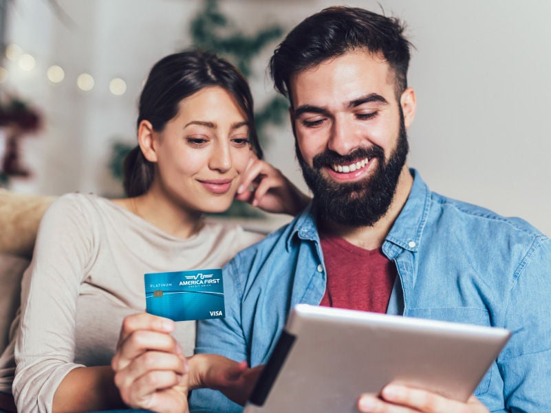 A man and woman looking at a smartphone and smiling.