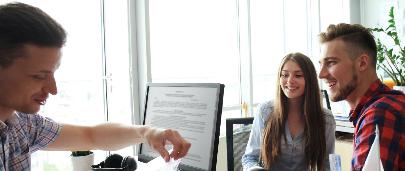 An image of a couple hving documents reviewed by a notary.