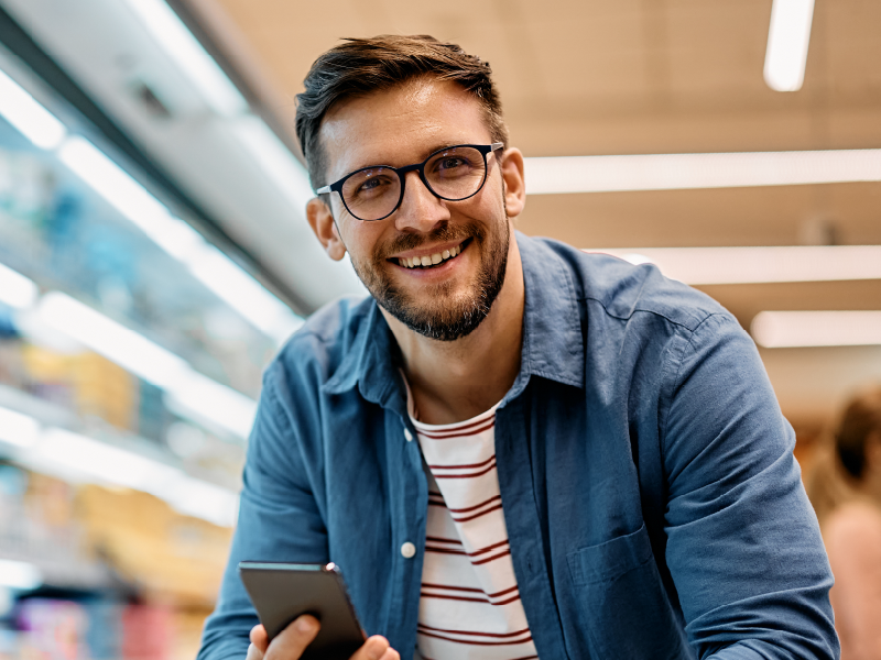 A man on a phone in a grocery store. 