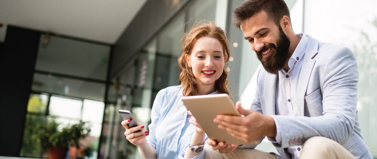 Two people looking at a tablet